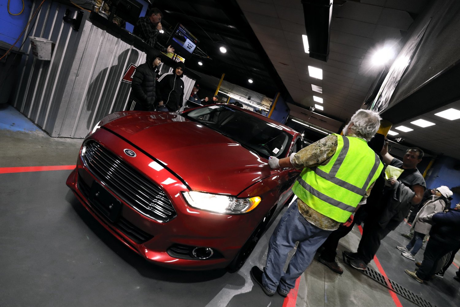 A red SUV moving through a busy Delaware Auto Exchange auction lane